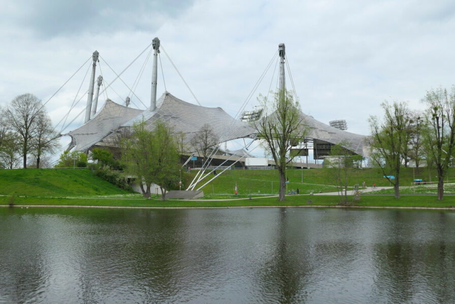 Das Zeltdach des Münchner Olympiastadions lässt sich vom See in voller Gänze bewundern